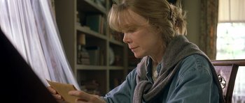 Movie still from “In the Bedroom” (2001), directed by Todd Field – A woman sitting in front of a bookshelf reading a paper; Close Up shot, Low angle