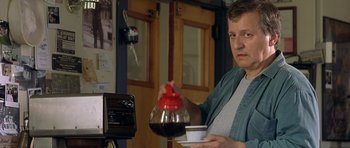Movie still from “In the Bedroom” (2001), directed by Todd Field – A man pouring a cup of coffee into a coffee pot; Close Up shot, Over the shoulder angle