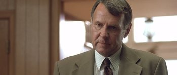 Movie still from “In the Bedroom” (2001), directed by Todd Field – An older man in a suit and tie looking at the camera; Close Up shot, Over the shoulder angle