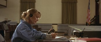 Movie still from “In the Bedroom” (2001), directed by Todd Field – A woman wearing a headset writing on a piece of paper; Medium shot, High angle