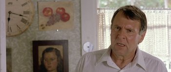 Movie still from “In the Bedroom” (2001), directed by Todd Field – An older man standing in front of a painting; Close Up shot, Over the shoulder angle