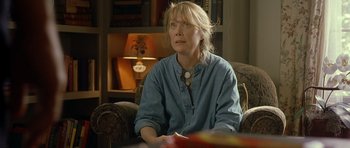 Movie still from “In the Bedroom” (2001), directed by Todd Field – A woman sitting in a chair in front of a table; Close Up shot, Over the shoulder angle