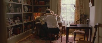 Movie still from “In the Bedroom” (2001), directed by Todd Field – A man and a woman sitting on a chair in front of a window; Wide shot, Over the shoulder angle