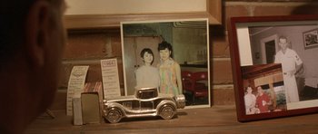 Movie still from “In the Bedroom” (2001), directed by Todd Field – An old photo of two girls in a dress and a car; Extreme Close Up shot, High angle