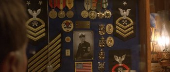 Movie still from “In the Bedroom” (2001), directed by Todd Field – A collection of military medals and insignia on a wall; Extreme Close Up shot, Overhead angle