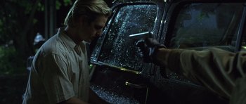 Movie still from “In the Bedroom” (2001), directed by Todd Field – A man is holding a cigarette in front of a car; Close Up shot, Over the shoulder angle