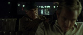 Movie still from “In the Bedroom” (2001), directed by Todd Field – An older man sitting in the back seat of a car; Close Up shot, Over the shoulder angle