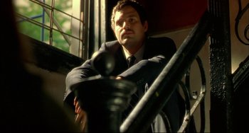 Movie still from “In the Cut” (2003), directed by Jane Campion – A man in a suit sitting in a chair; Close Up shot, Low angle