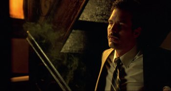 Movie still from “In the Cut” (2003), directed by Jane Campion – A man in a suit sitting in front of a piano; Close Up shot, Low angle