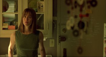 Movie still from “In the Cut” (2003), directed by Jane Campion – A woman standing in front of a mirror in a room; Medium shot, Low angle