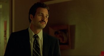 Movie still from “In the Cut” (2003), directed by Jane Campion – A man wearing a suit and tie standing in a room; Close Up shot, Low angle