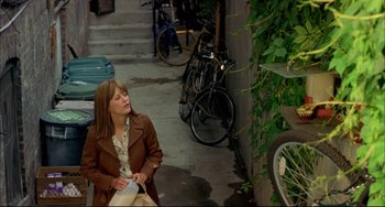 Movie still from “In the Cut” (2003), directed by Jane Campion – A woman sitting on the ground next to a bicycle; Wide shot, High angle