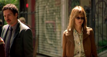 Movie still from “In the Cut” (2003), directed by Jane Campion – A woman wearing sunglasses walking down a street; Medium shot, Low angle