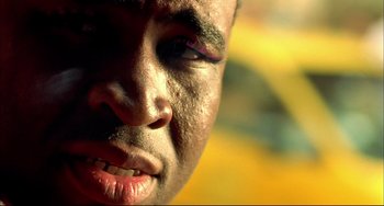 Movie still from “In the Cut” (2003), directed by Jane Campion – A man's face with a yellow background; Extreme Close Up shot, Low angle