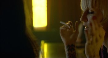 Movie still from “In the Cut” (2003), directed by Jane Campion – A person smoking a cigarette while holding a cell phone in their hand; Close Up shot, Over the shoulder angle