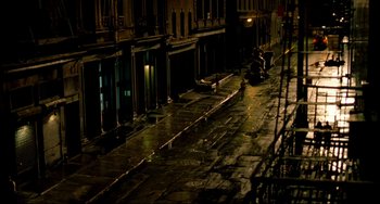 Movie still from “In the Cut” (2003), directed by Jane Campion – A person riding a motorcycle down a street at night; Extreme Wide shot, High angle