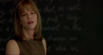 Movie still from “In the Cut” (2003), directed by Jane Campion – A woman with a brown dress is standing in front of a chalkboard; Close Up shot, Over the shoulder angle