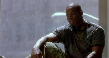 Movie still from “In the Cut” (2003), directed by Jane Campion – A man sitting in front of a window with headphones on; Medium shot, Low angle