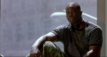 Movie still from “In the Cut” (2003), directed by Jane Campion – A man sitting in front of a window with rain coming through the window; Medium shot, Low angle