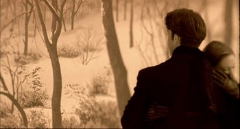 Movie still from “In the Cut” (2003), directed by Jane Campion – A woman standing in the snow looking at trees; Medium shot, Over the shoulder angle