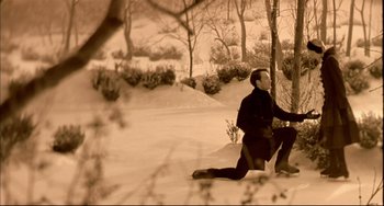 Movie still from “In the Cut” (2003), directed by Jane Campion – A man kneeling down in the snow near a tree; Wide shot, High angle