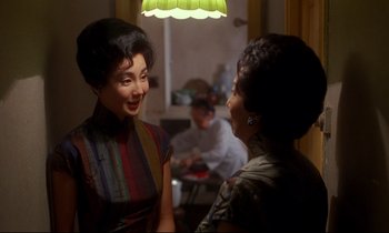 Movie still from “In the Mood for Love” (2000), directed by Kar-Wai Wong – Two women are talking to each other in a room; Medium shot, Over the shoulder angle