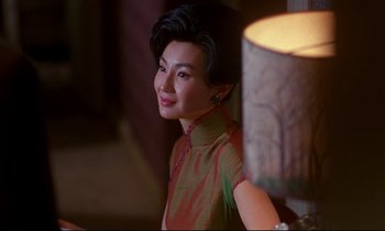 Movie still from “In the Mood for Love” (2000), directed by Kar-Wai Wong – A woman sitting in front of a table lamp; Close Up shot, Over the shoulder angle