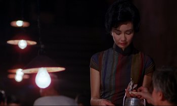 Movie still from “In the Mood for Love” (2000), directed by Kar-Wai Wong – A woman holding a cell phone in her hand; Medium shot, Over the shoulder angle