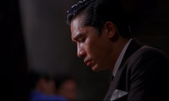 Movie still from “In the Mood for Love” (2000), directed by Kar-Wai Wong – A person wearing a suit and tie; Close Up shot, Low angle