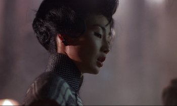 Movie still from “In the Mood for Love” (2000), directed by Kar-Wai Wong – A person wearing a ear piece; Close Up shot, Over the shoulder angle
