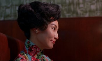 Movie still from “In the Mood for Love” (2000), directed by Kar-Wai Wong – A woman in a floral dress is looking to the side; Close Up shot, Over the shoulder angle