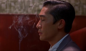 Movie still from “In the Mood for Love” (2000), directed by Kar-Wai Wong – A person smoking a cigarette; Close Up shot, High angle