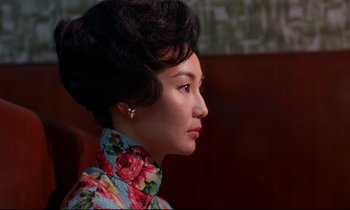 Movie still from “In the Mood for Love” (2000), directed by Kar-Wai Wong – A woman in a floral dress looking to her left; Close Up shot, Over the shoulder angle
