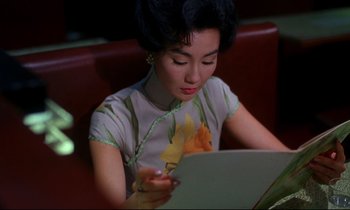 Movie still from “In the Mood for Love” (2000), directed by Kar-Wai Wong – A woman sitting in front of an open laptop computer; Close Up shot, High angle