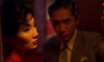 Movie still from “In the Mood for Love” (2000), directed by Kar-Wai Wong – A man and a woman are looking at each other; Close Up shot, Over the shoulder angle