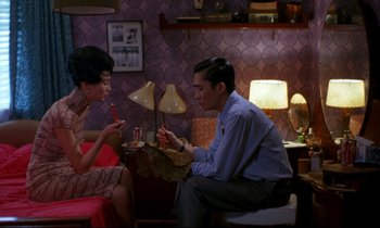 Movie still from “In the Mood for Love” (2000), directed by Kar-Wai Wong – A man and a woman sitting in a room; Medium shot, High angle