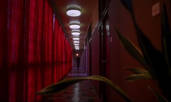 Movie still from “In the Mood for Love” (2000), directed by Kar-Wai Wong – A person is walking down a hallway in a building; Extreme Wide shot, Low angle
