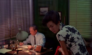 Movie still from “In the Mood for Love” (2000), directed by Kar-Wai Wong – A man and a woman sitting at a table; Medium shot, Over the shoulder angle