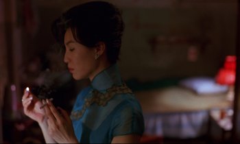 Movie still from “In the Mood for Love” (2000), directed by Kar-Wai Wong – A woman in a blue dress is holding a cigarette; Close Up shot, Over the shoulder angle