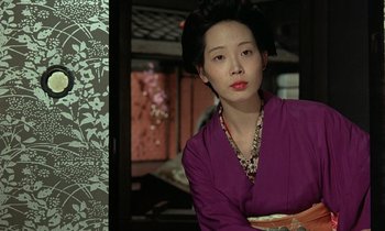 Movie still from “In the Realm of the Senses” (1976), directed by Nagisa Ôshima – A woman in a purple kimono is posing for a picture; Close Up shot, Low angle
