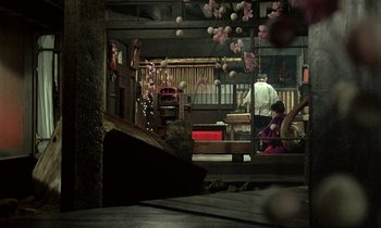 Movie still from “In the Realm of the Senses” (1976), directed by Nagisa Ôshima – A man and a woman in a room with pink decorations; Extreme Wide shot, High angle