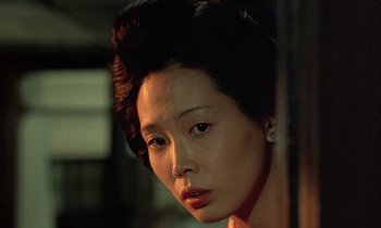 Movie still from “In the Realm of the Senses” (1976), directed by Nagisa Ôshima – A person wearing a wig; Close Up shot, Over the shoulder angle