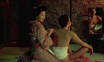 Movie still from “In the Realm of the Senses” (1976), directed by Nagisa Ôshima – A man and a woman sitting on the ground; Medium shot, Over the shoulder angle