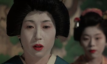 Movie still from “In the Realm of the Senses” (1976), directed by Nagisa Ôshima – A geisha with a white face and a black wig; Close Up shot, Low angle