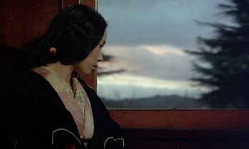 Movie still from “In the Realm of the Senses” (1976), directed by Nagisa Ôshima – A woman in a kimono looking out of a window; Medium shot, Low angle