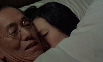 Movie still from “In the Realm of the Senses” (1976), directed by Nagisa Ôshima – An older woman laying in bed next to a younger woman; Close Up shot, High angle