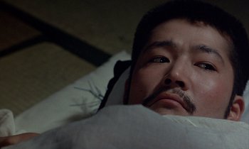 Movie still from “In the Realm of the Senses” (1976), directed by Nagisa Ôshima – A person laying in a bed; Close Up shot, High angle