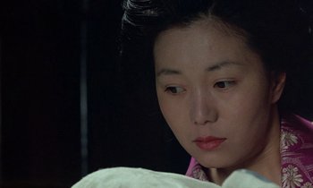 Movie still from “In the Realm of the Senses” (1976), directed by Nagisa Ôshima – A person wearing a pink shirt; Close Up shot, High angle
