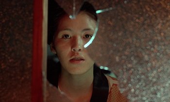 Movie still from “In the Realm of the Senses” (1976), directed by Nagisa Ôshima – A young woman looking out of a window at night; Close Up shot, Low angle
