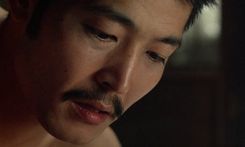 Movie still from “In the Realm of the Senses” (1976), directed by Nagisa Ôshima – A person with a mustache; Extreme Close Up shot, High angle